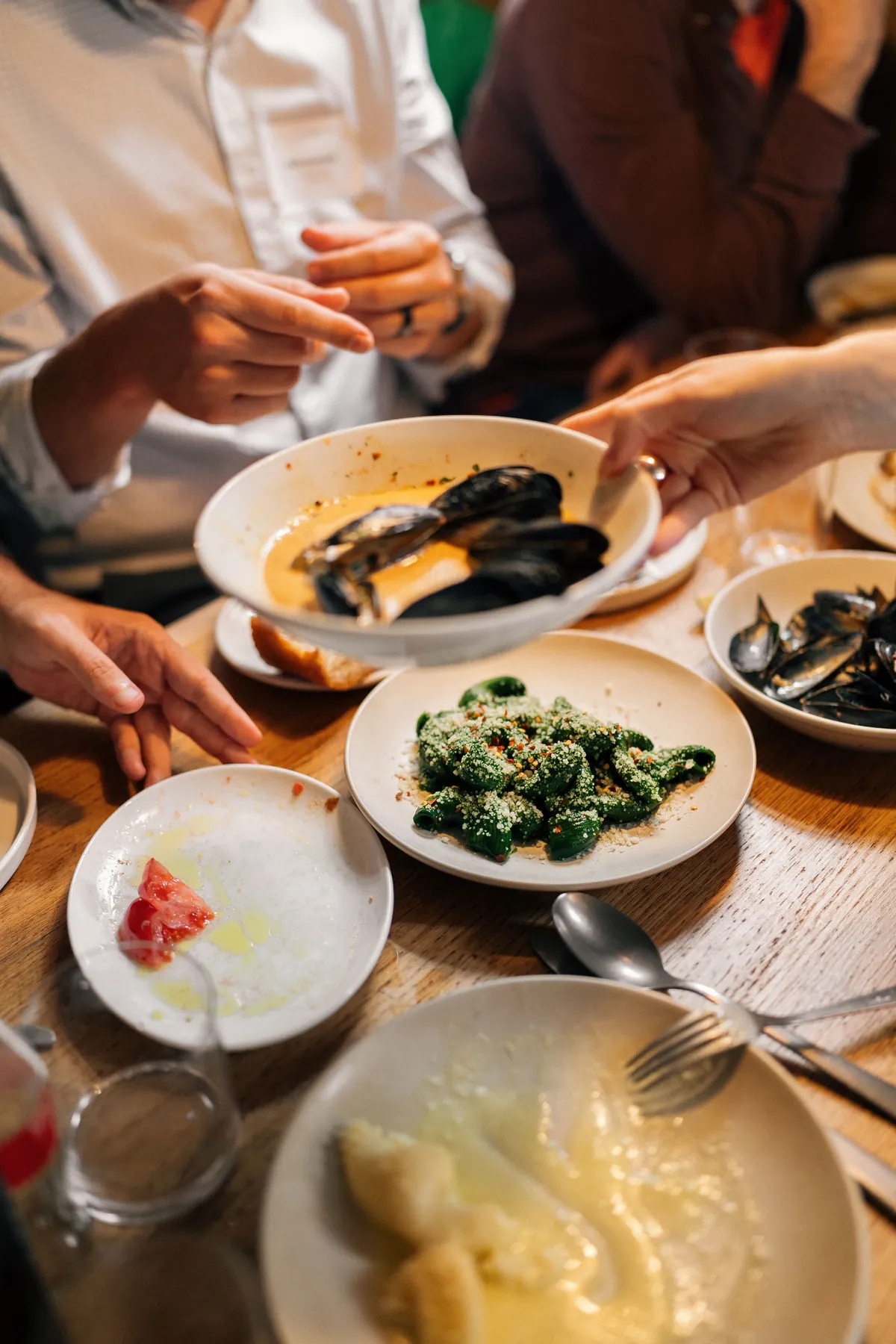 People sharing dishes around a wooden table